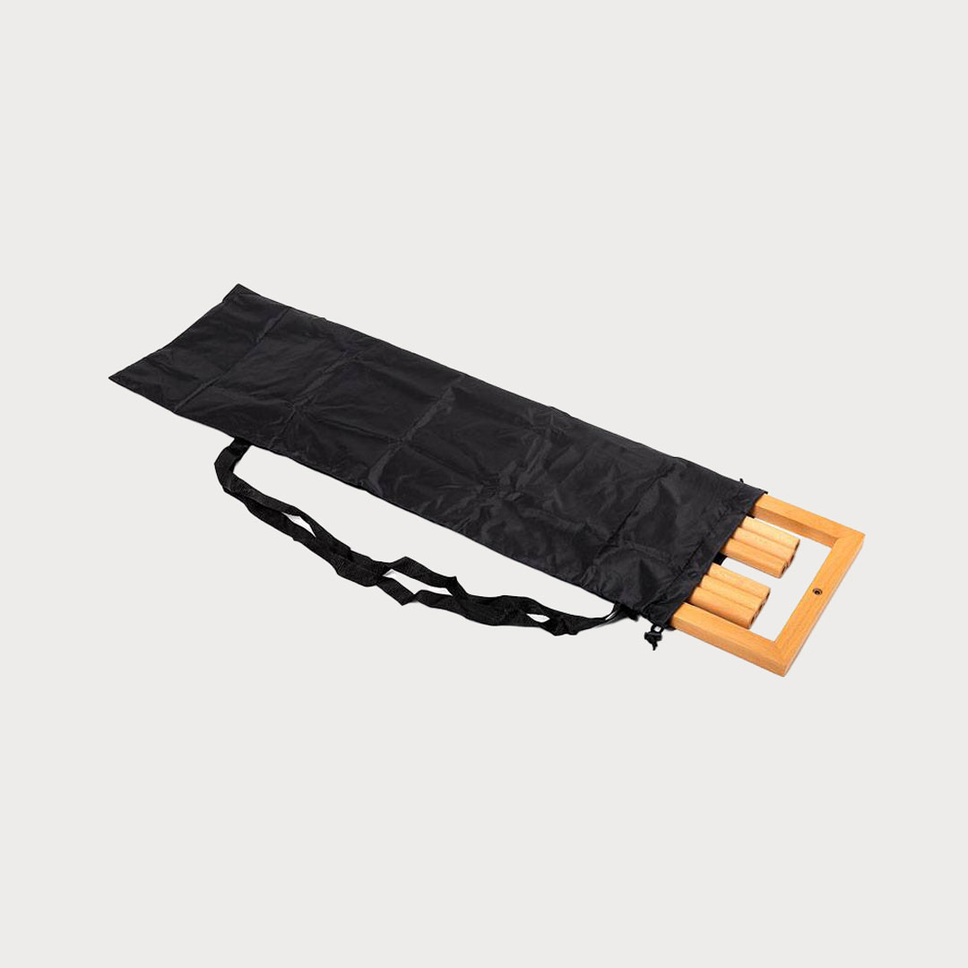 Ein länglicher, schwarzer Transportbeutel mit Tragegurt enthält die zerlegten Holzstreben eines Banner-Displays.